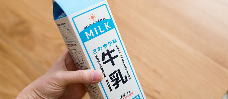 牛乳パックを持つ手元